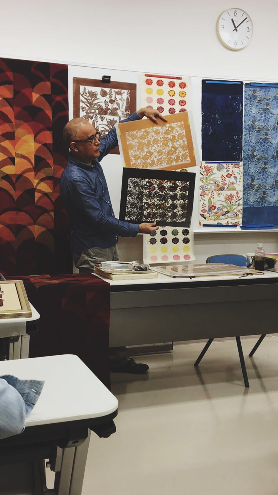 A Professor from Okinawa Prefectural University of Art showing Stevens' study abroad class materials used to make traditional Okinawa bingata prints. Whytne draws a lot of inspiration from Japanese design and aesthetics, particularly in her linocuts.